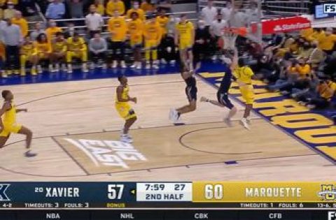 Marquette’s Kam Jones with the acrobatic up and under lay-up