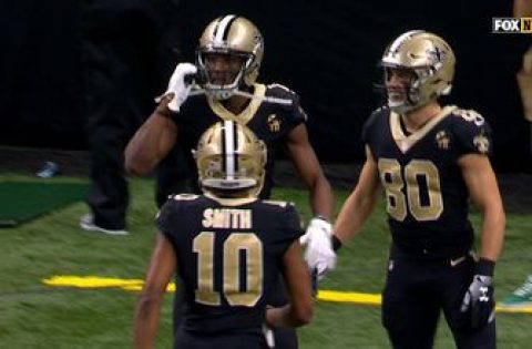 Michael Thomas pulls a cellphone out from under the goalpost after 72-yard touchdown catch