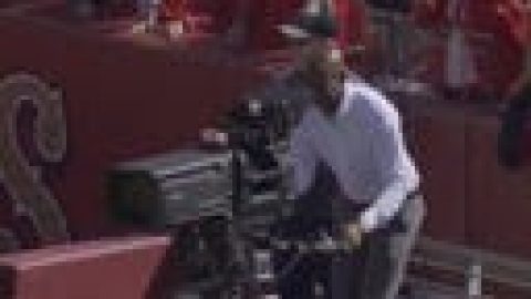 FOX cameraman Andy Mitchell shows 49ers legend Jerry Rice how to operate the end-zone camera